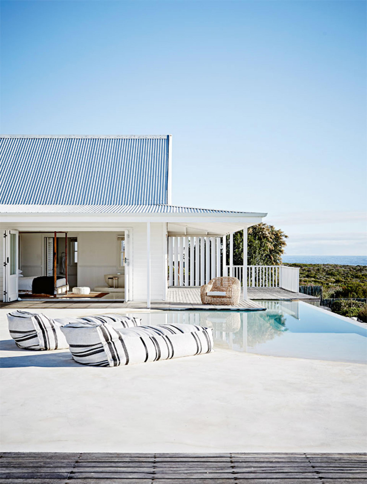 It’s the casual nature of this home that really appeals to me, along with the all white palette! I LOVE an all white house. The whitewashed wooden floors are perfect for barefoot summer days and the distressed and weathered wooden elements and furniture round off the casual feeling. For that essential open plan, indoor / outdoor living, the bi-fold doors open onto the patio surrounding the house, while the infinity pool facing the ocean is the piece de resistance of this dream home.